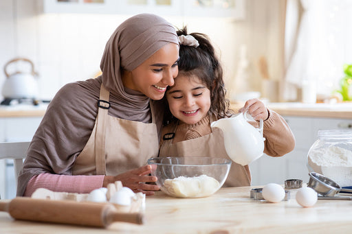 A mother and daughter baking goods in their kitchen that is free from pantry moths due to Moth Prevention's Pantry Moth Traps.