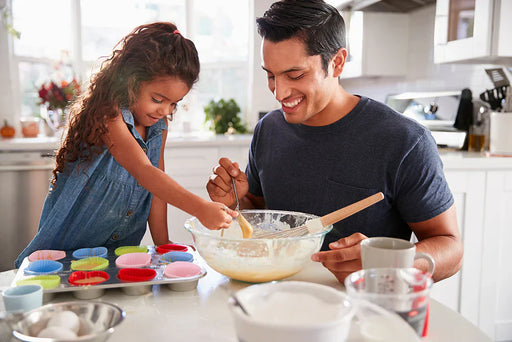 A father and daughter baking cupcakes in their kitchen that is free from a pantry moth infestation