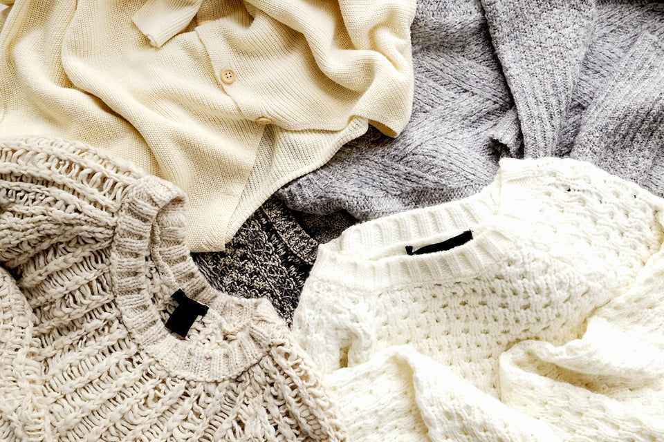 a selection of sweaters loosely layered on top of each other