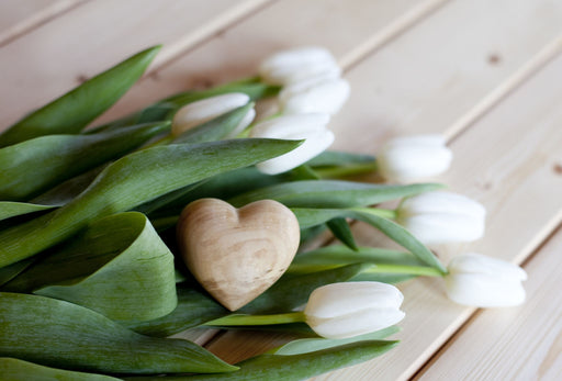 a heart shaped cedar block with white tulips