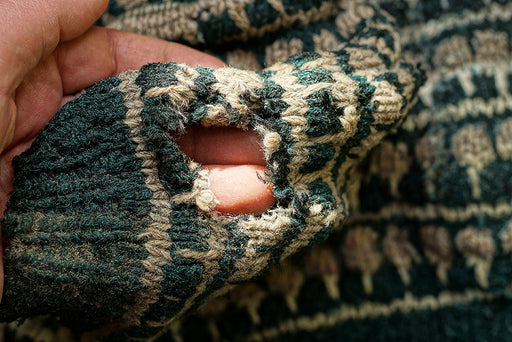 a close up of a hole in a woolen sweater