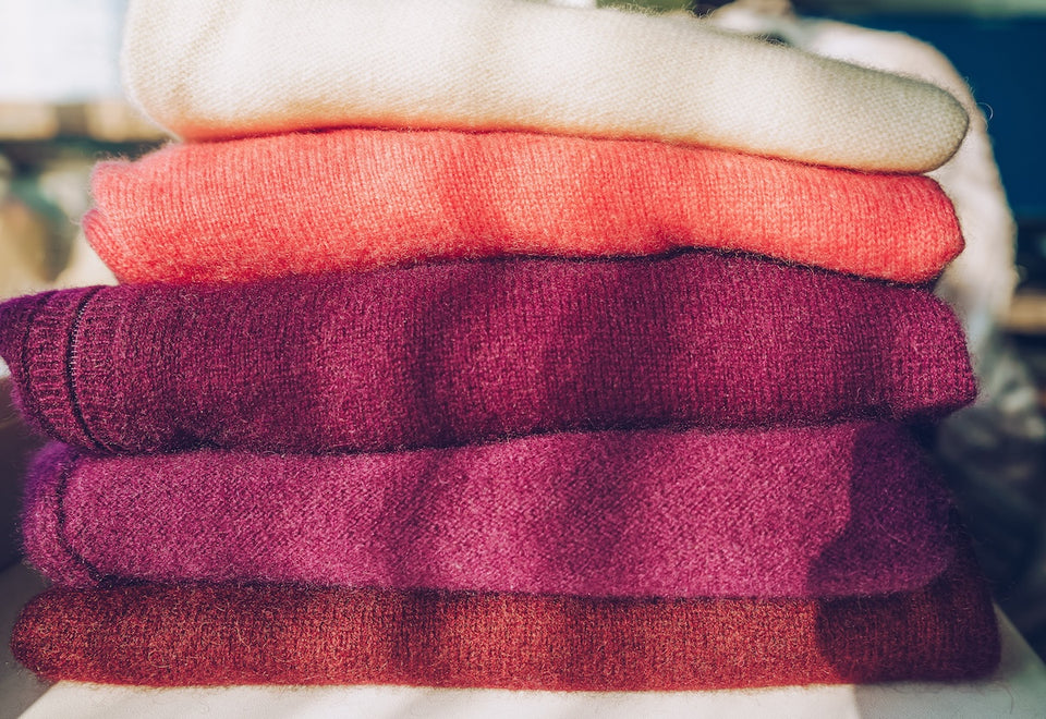 a pile of folded colourful cashmere jumpers