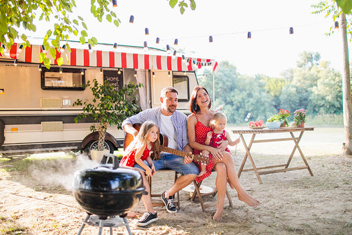 a family sitting in front of their camper van in a beautiful setting