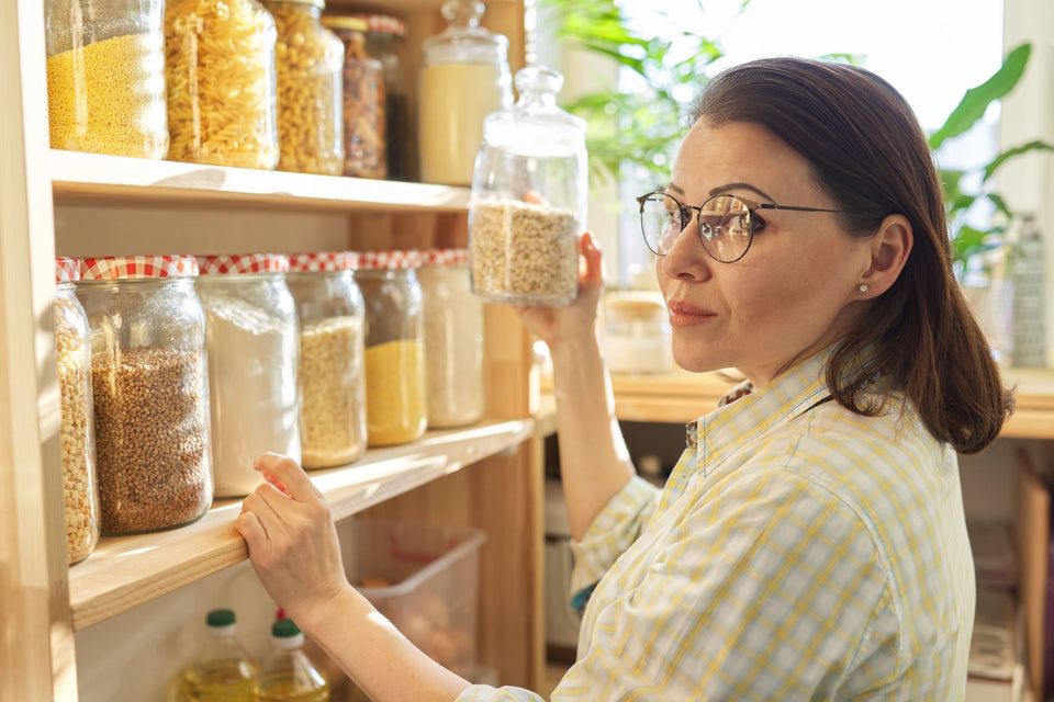woman with shelves full of dried foodstuffs in sealed containers