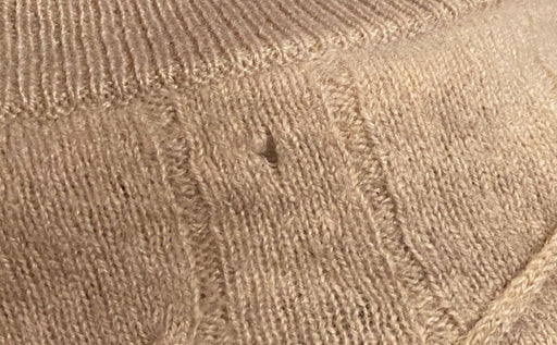 a woolen sweater which has been eaten by moth larvae