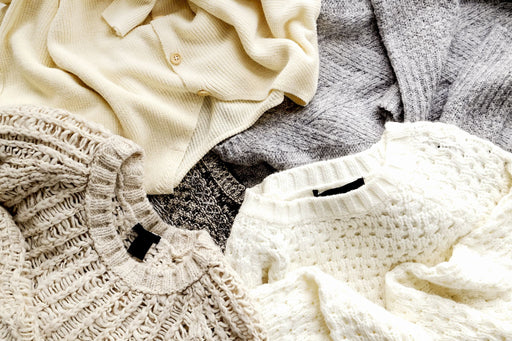 a selection of sweaters  loosely layered on top of each other