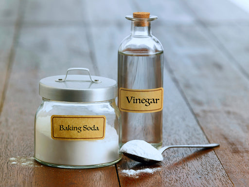 a jar of baking soda and bottle of white cleaning vinegar
