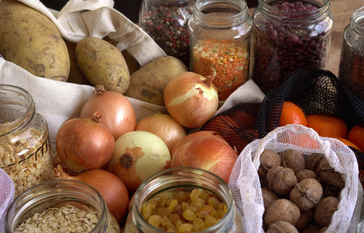 a selection of unsealed food stuffs including seeds, raisins, nuts, beans and potatoes