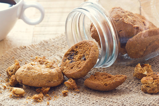 an open cookie jar with cookies spilling out of it