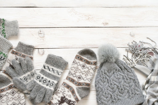 a selection of woolen gloves, socks and a bobble hat