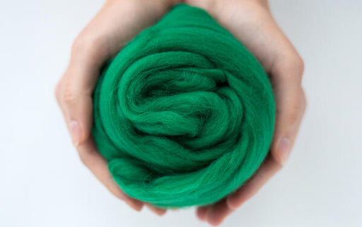 hands holding green merino wool