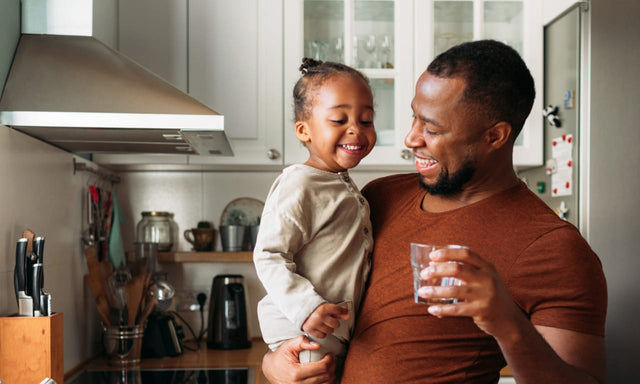 smiling father and daughter in kitchen