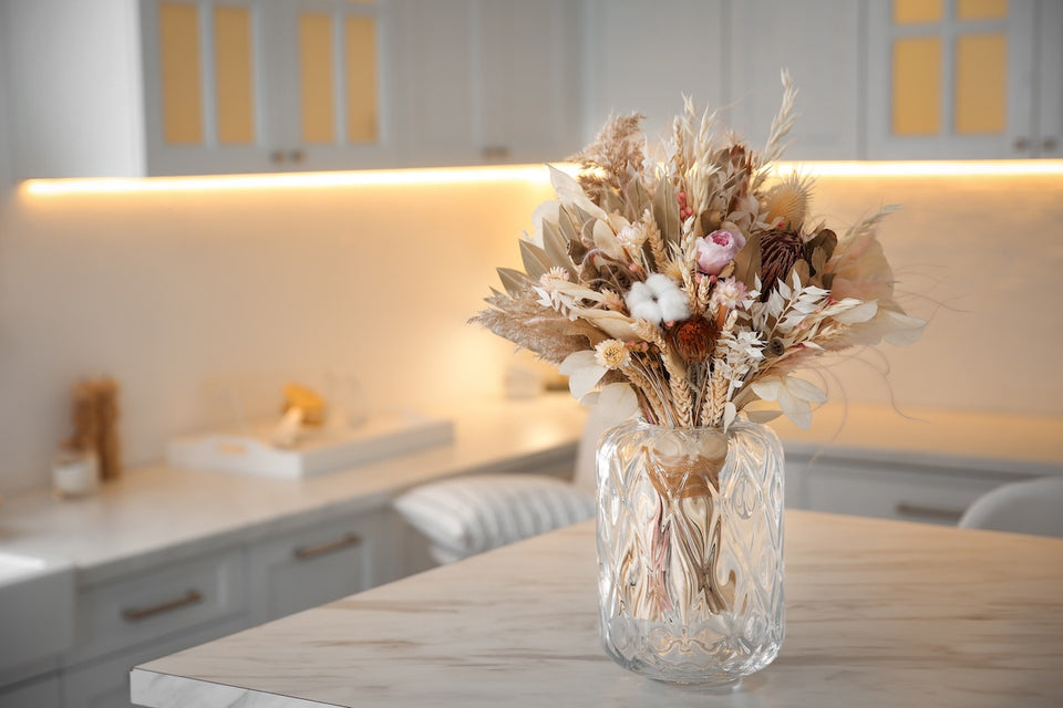 a vase of dried flowers on a kitchen island