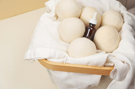 woolen dryer balls with a bottle of essential oil