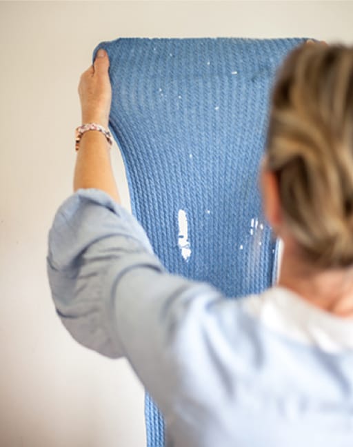 woman holding up garment with moth damage